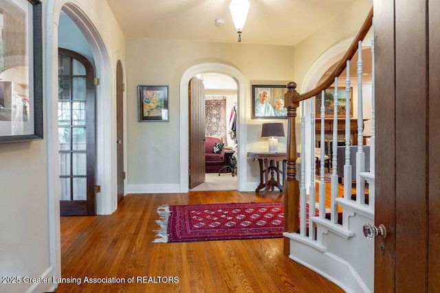 620 Ardson Rd, East Lansing, MI 48823 - entryway with arched walkways, wood finished floors, baseboards, and stairway