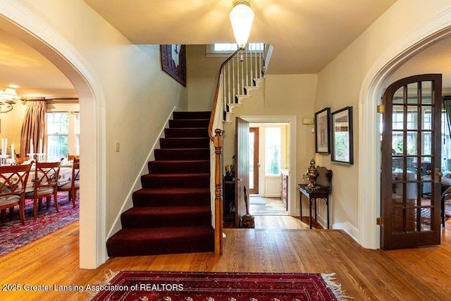 620 Ardson Rd, East Lansing, MI 48823 - entrance foyer with arched walkways, stairs, wood finished floors, and baseboards