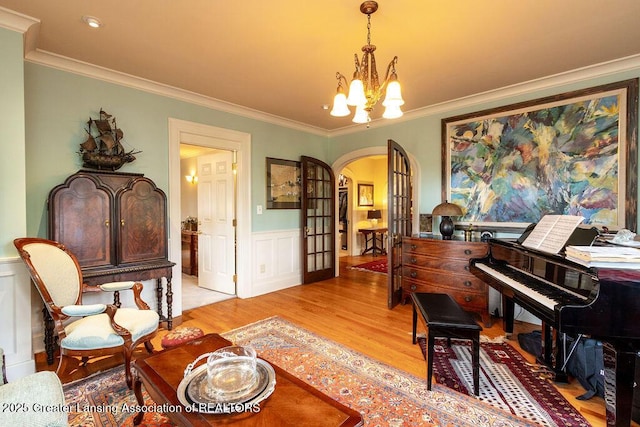 620 Ardson Rd, East Lansing, MI 48823 - sitting room featuring arched walkways, a chandelier, crown molding, wood finished floors, and wainscoting
