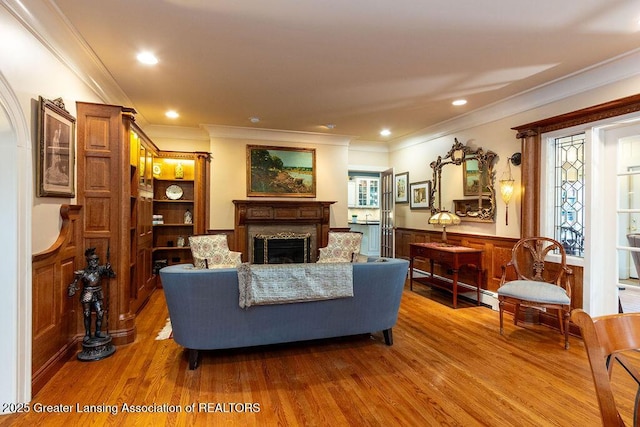 620 Ardson Rd, East Lansing, MI 48823 - living area with wood finished floors, a fireplace, crown molding, a wainscoted wall, and recessed lighting
