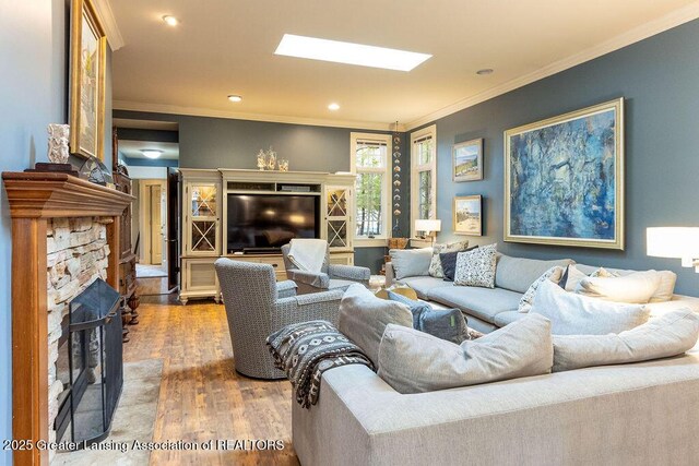 620 Ardson Rd, East Lansing, MI 48823 - living area featuring a stone fireplace, ornamental molding, wood finished floors, and recessed lighting