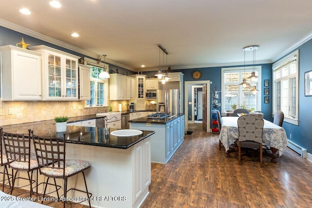 620 Ardson Rd, East Lansing, MI 48823 - kitchen with stainless steel appliances, a center island, crown molding, dark wood-style floors, and backsplash