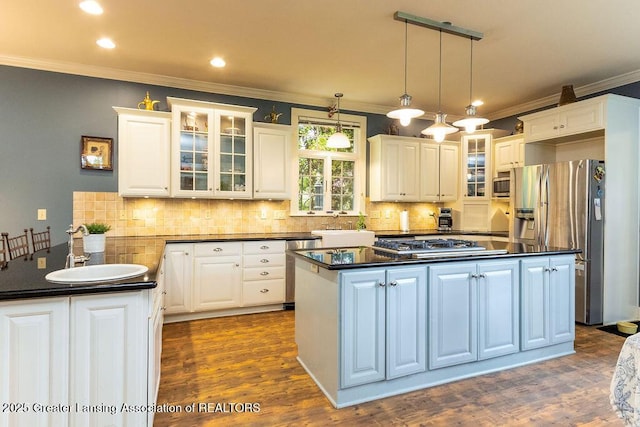 620 Ardson Rd, East Lansing, MI 48823 - kitchen with appliances with stainless steel finishes, a sink, dark countertops, crown molding, and white cabinetry