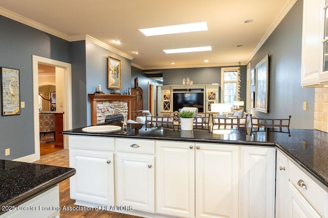 620 Ardson Rd, East Lansing, MI 48823 - kitchen featuring a fireplace, dark wood-type flooring, crown molding, white cabinets, and open floor plan