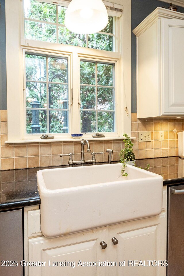 620 Ardson Rd, East Lansing, MI 48823 - kitchen with dark countertops, decorative backsplash, white cabinets, and healthy amount of natural light