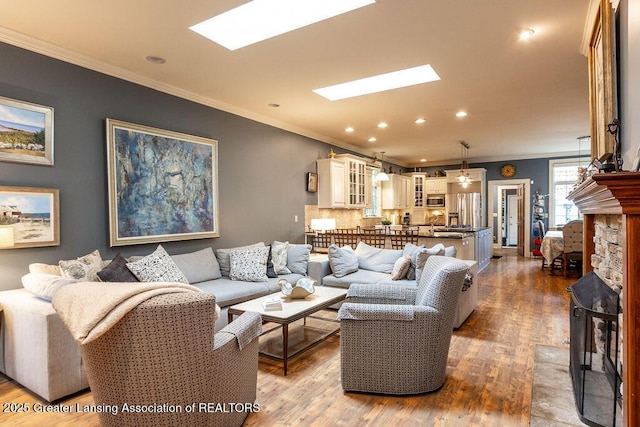 620 Ardson Rd, East Lansing, MI 48823 - living area with dark wood-style floors, crown molding, a skylight, and recessed lighting