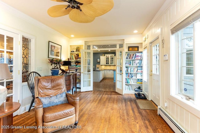 620 Ardson Rd, East Lansing, MI 48823 - sitting room featuring baseboard heating, wood finished floors, ornamental molding, a ceiling fan, and recessed lighting