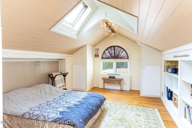 620 Ardson Rd, East Lansing, MI 48823 - bedroom with a skylight, lofted ceiling, multiple windows, light wood-style flooring, and wood walls