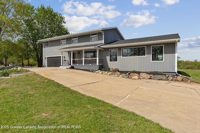 1551 E Lovejoy Rd, Perry, MI 48872 - view of front of house with covered porch, a garage, concrete driveway, and a front yard