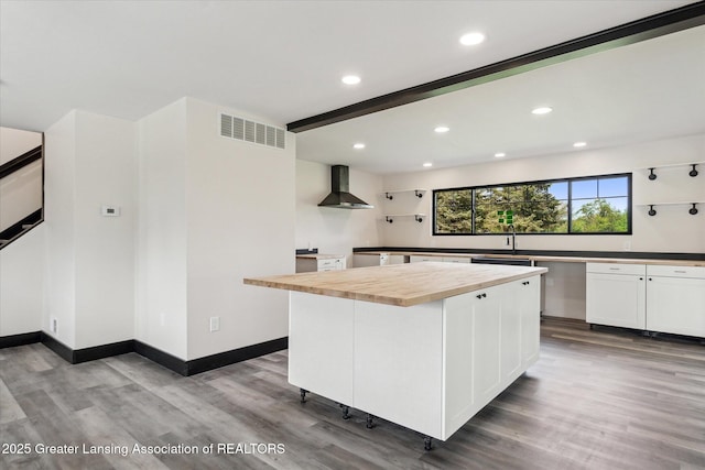 1551 E Lovejoy Rd, Perry, MI 48872 - kitchen featuring wall chimney range hood, butcher block countertops, wood finished floors, a sink, and recessed lighting