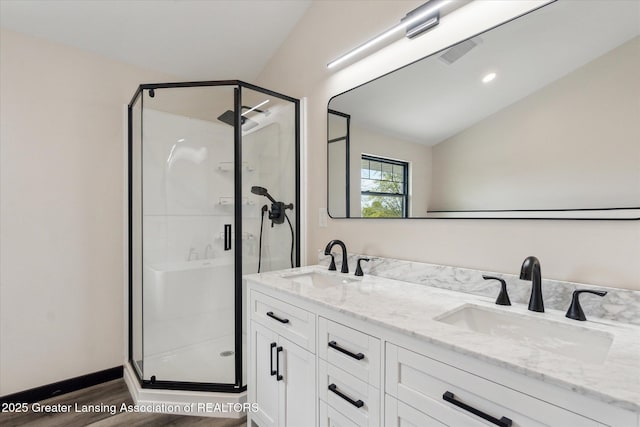 1551 E Lovejoy Rd, Perry, MI 48872 - full bathroom featuring wood finished floors, a stall shower, double vanity, and vaulted ceiling