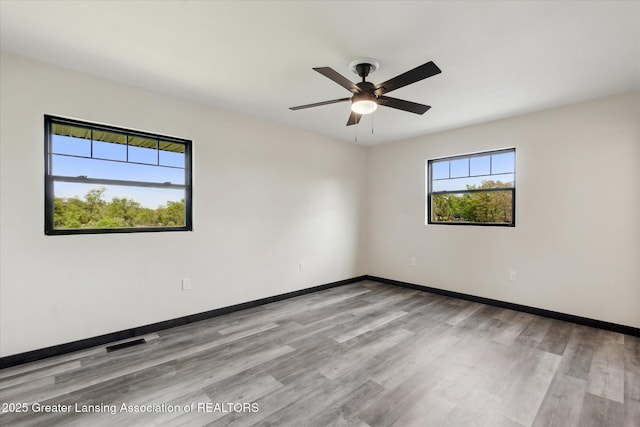1551 E Lovejoy Rd, Perry, MI 48872 - unfurnished room featuring wood finished floors, ceiling fan, and baseboards