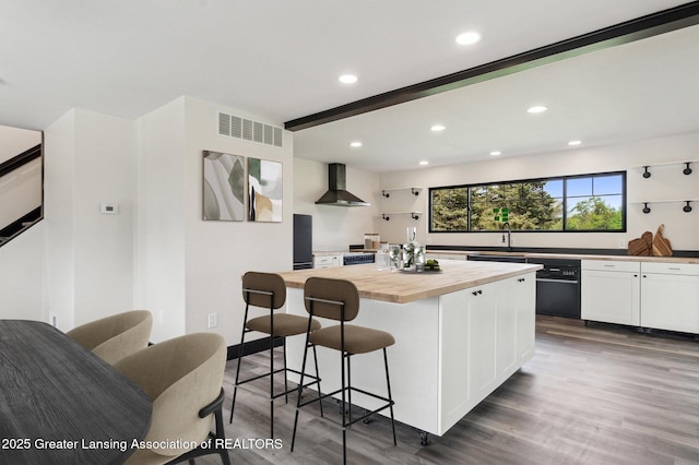 1551 E Lovejoy Rd, Perry, MI 48872 - kitchen featuring wooden counters, wall chimney exhaust hood, a sink, white cabinetry, and dark wood-style floors