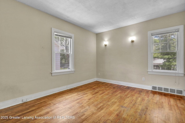unfurnished room with wood finished floors and baseboards