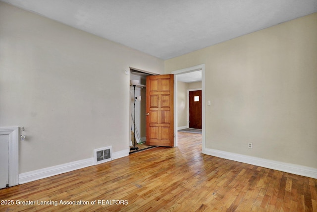 spare room featuring baseboards and light wood-style flooring