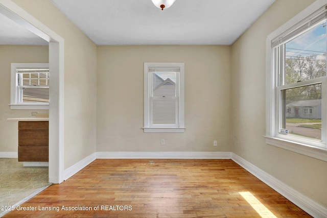 unfurnished room with light wood-style floors and baseboards