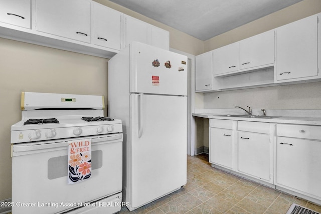 kitchen with white appliances, a sink, light countertops, and white cabinetry