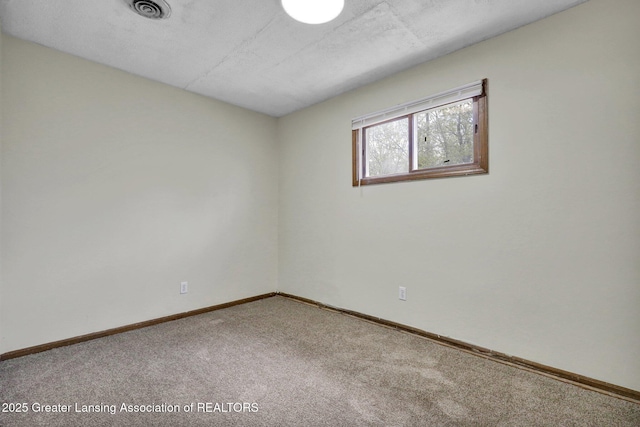 empty room featuring carpet flooring and baseboards