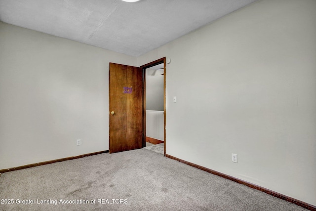 carpeted spare room with baseboards