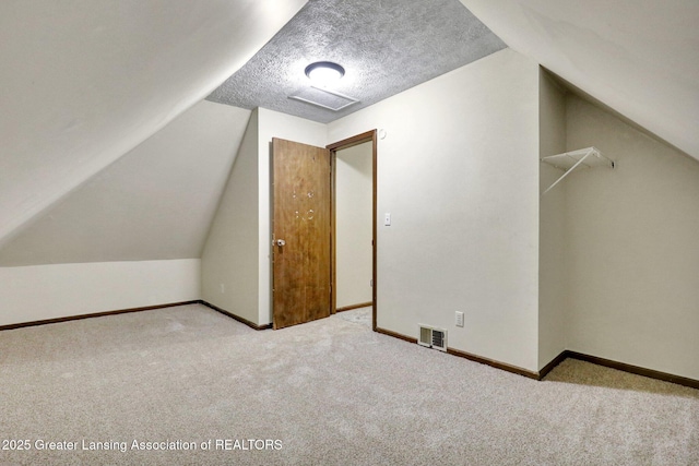 bonus room featuring carpet floors, lofted ceiling, baseboards, and a textured ceiling