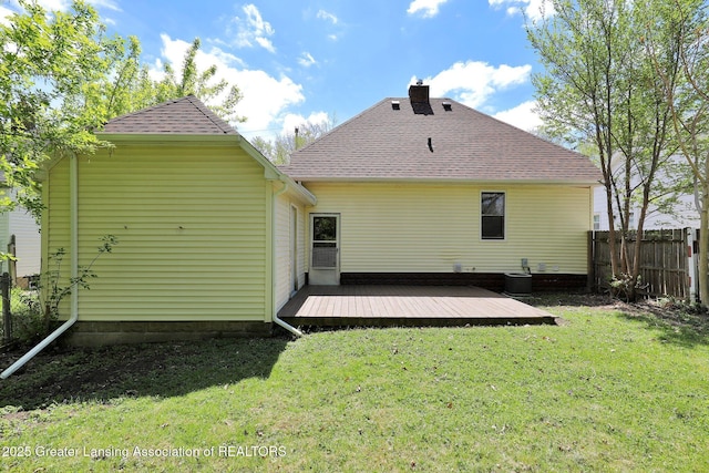 back of property with a wooden deck, a chimney, a shingled roof, and central air condition unit