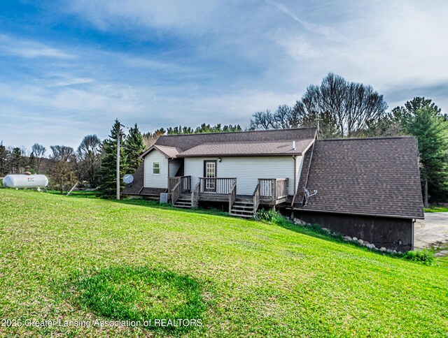 rear view of house with a deck and a lawn