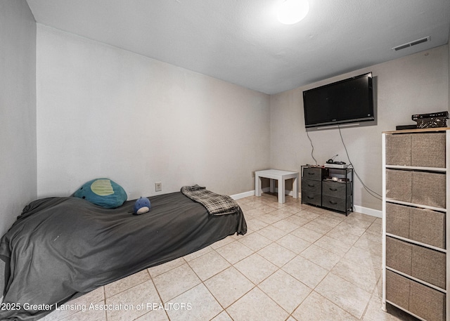 bedroom with baseboards, visible vents, and light tile patterned floors