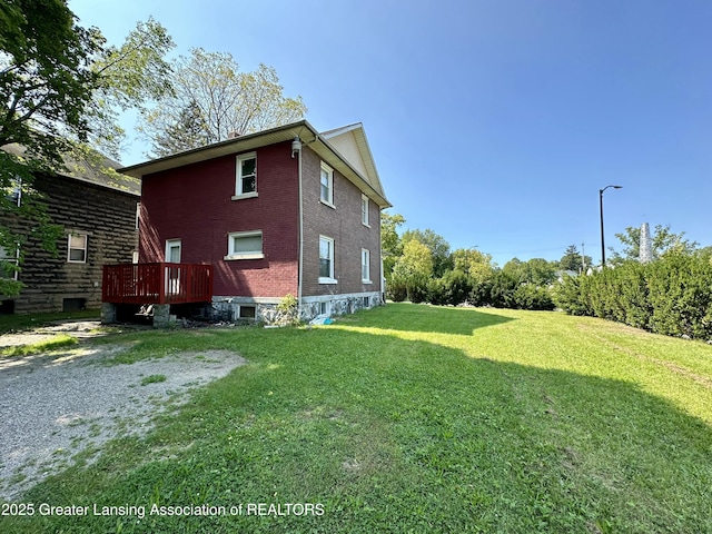 view of home's exterior with a yard and brick siding