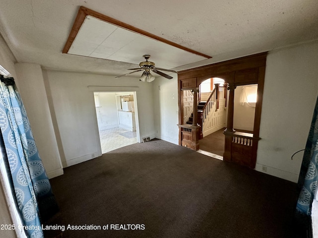 unfurnished room with baseboards, carpet flooring, stairs, and ceiling fan
