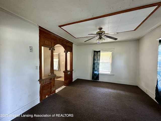 unfurnished room featuring ceiling fan, ornamental molding, baseboards, and dark carpet