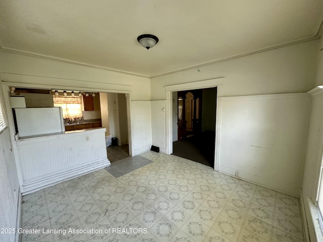 unfurnished living room featuring baseboards and light floors