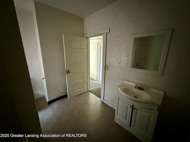 bathroom with baseboards, tile patterned floors, and vanity