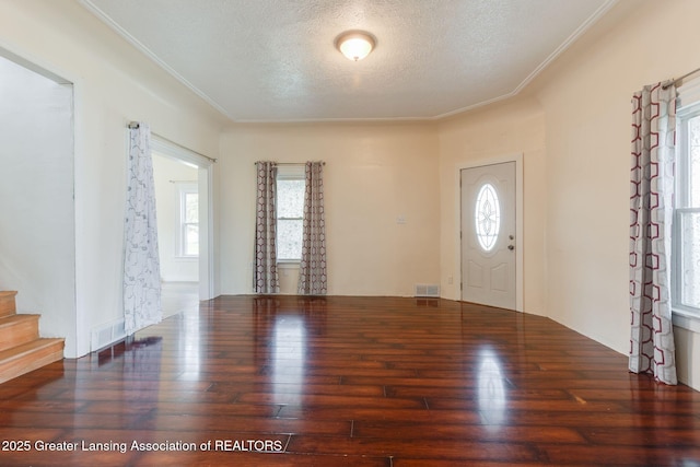 entrance foyer with plenty of natural light, hardwood / wood-style flooring, a textured ceiling, and visible vents