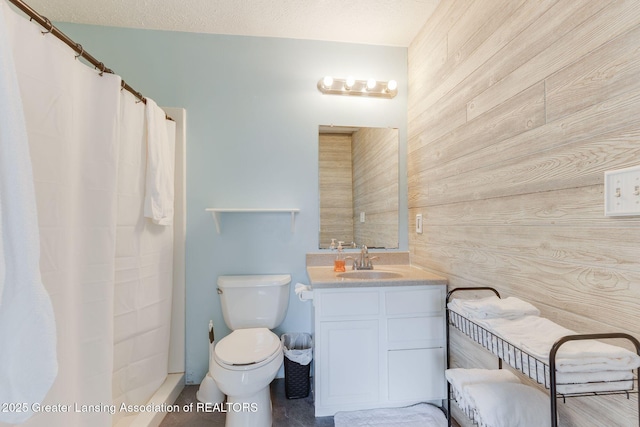 full bathroom featuring vanity, wooden walls, and toilet