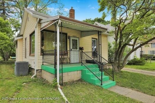 1600 S Pennsylvania Ave, Lansing, MI 48910 - view of front of property with central AC unit, a chimney, and a front lawn