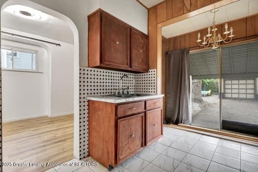 1600 S Pennsylvania Ave, Lansing, MI 48910 - kitchen featuring a chandelier, light countertops, tasteful backsplash, and brown cabinetry