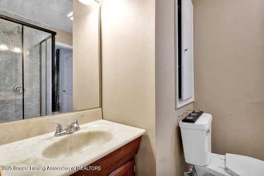 1600 S Pennsylvania Ave, Lansing, MI 48910 - bathroom with vanity, toilet, and a tile shower