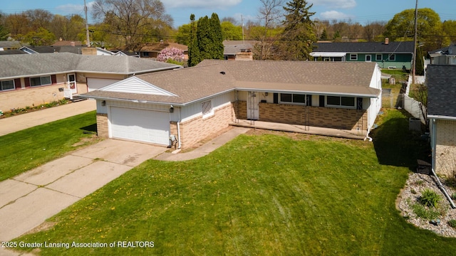 view of front facade featuring a front yard, roof with shingles, brick siding, an attached garage, and driveway