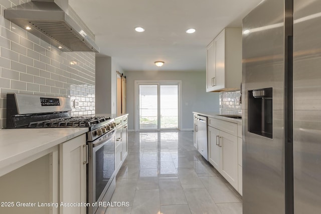 kitchen with recessed lighting, wall chimney exhaust hood, tasteful backsplash, light tile patterned floors, and stainless steel appliances