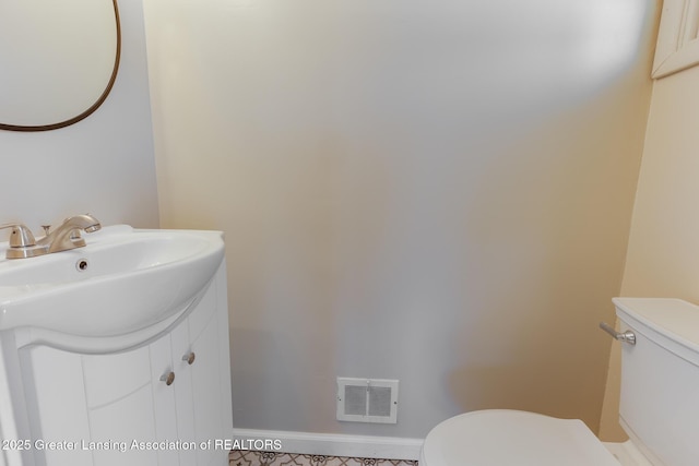 bathroom featuring visible vents, baseboards, toilet, and vanity