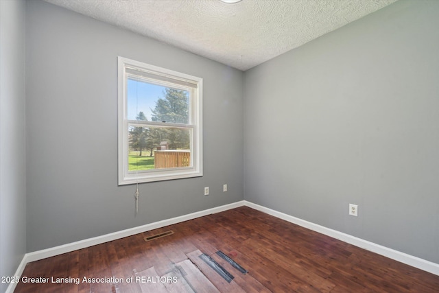 1971 N Michigan Rd, Eaton Rapids, MI 48827 - unfurnished room with visible vents, a textured ceiling, dark wood-style flooring, and baseboards