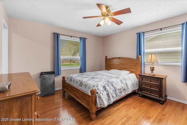 bedroom featuring baseboards, ceiling fan, and light wood-style floors