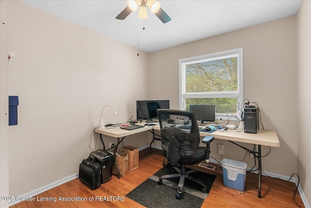 office space with baseboards, a ceiling fan, and wood finished floors