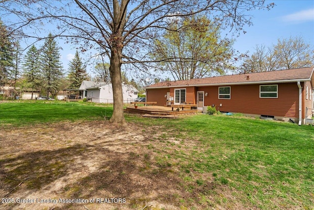 rear view of property featuring a yard, a deck, and fence