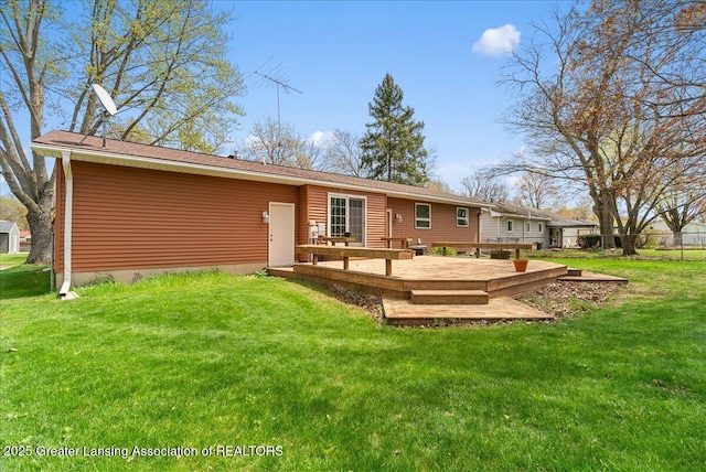 rear view of house with a yard and a wooden deck