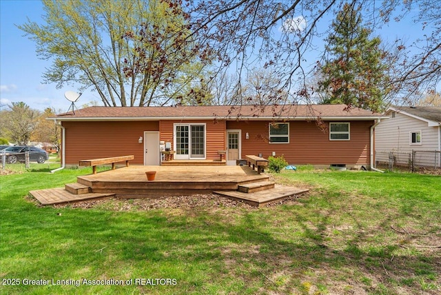 rear view of house featuring a lawn, fence, and a deck