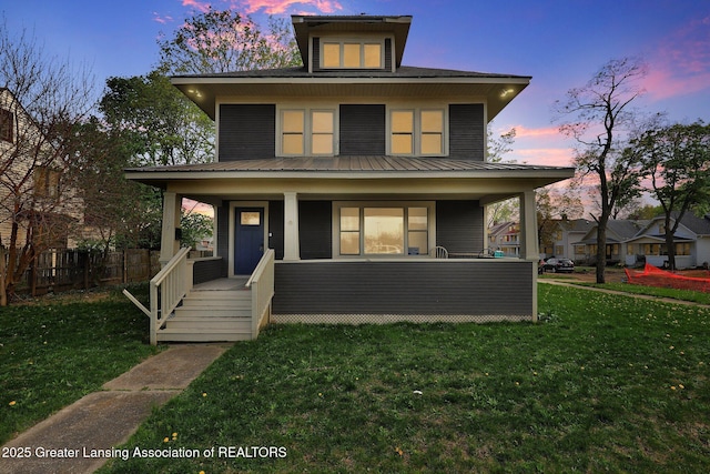 1127 W Saginaw St, Lansing, MI 48915 - american foursquare style home with a lawn, fence, and a porch