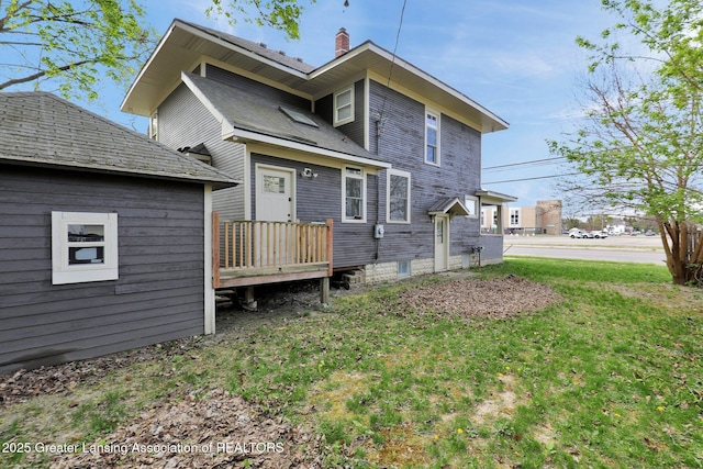 1127 W Saginaw St, Lansing, MI 48915 - rear view of house with a lawn and a chimney