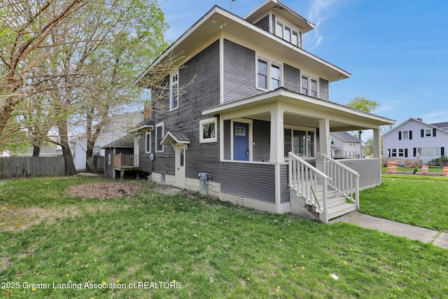 1127 W Saginaw St, Lansing, MI 48915 - traditional style home featuring a porch, fence, and a front lawn