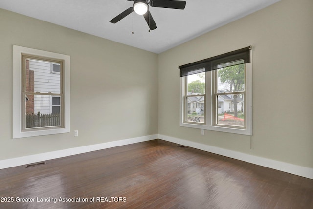 1127 W Saginaw St, Lansing, MI 48915 - spare room featuring baseboards, visible vents, ceiling fan, and dark wood-type flooring